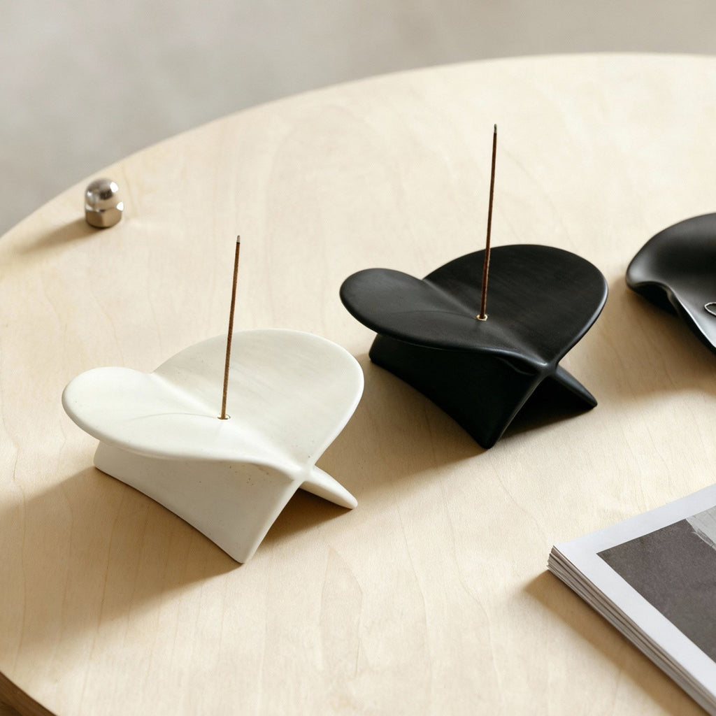 White and black airplane ceramic incense holders styled on a light wood table